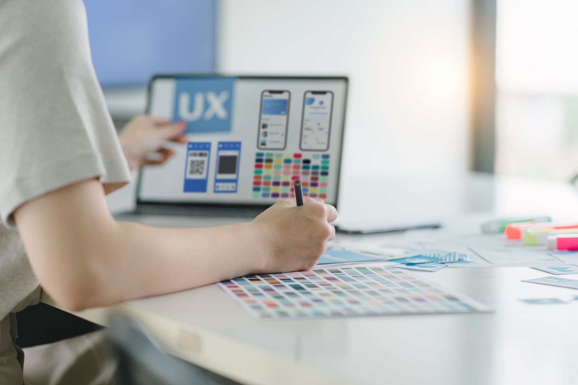 Creative ux ui designers team developing wireframe and sketching layout design mockup on smartphone screen.